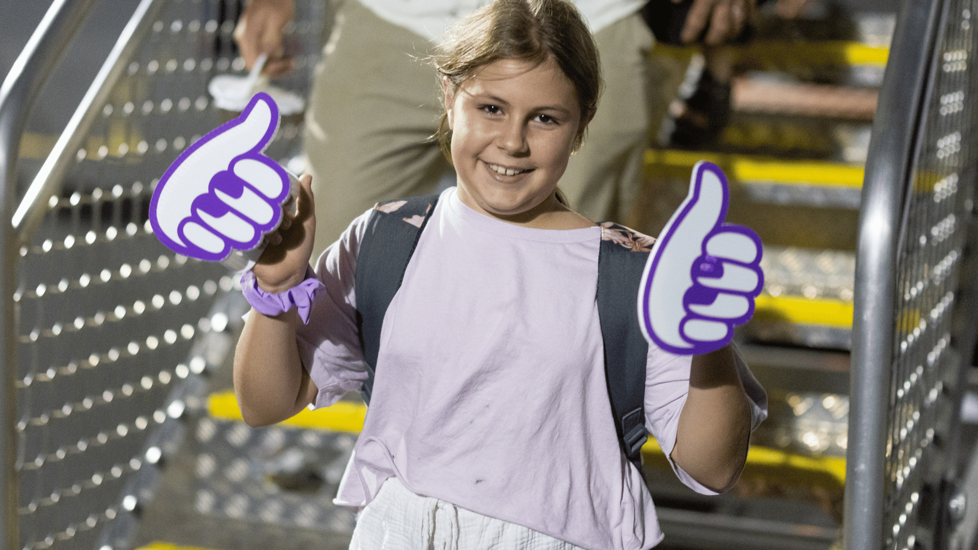 Young girl smiling with Bonza thumbs while departing aircraft.