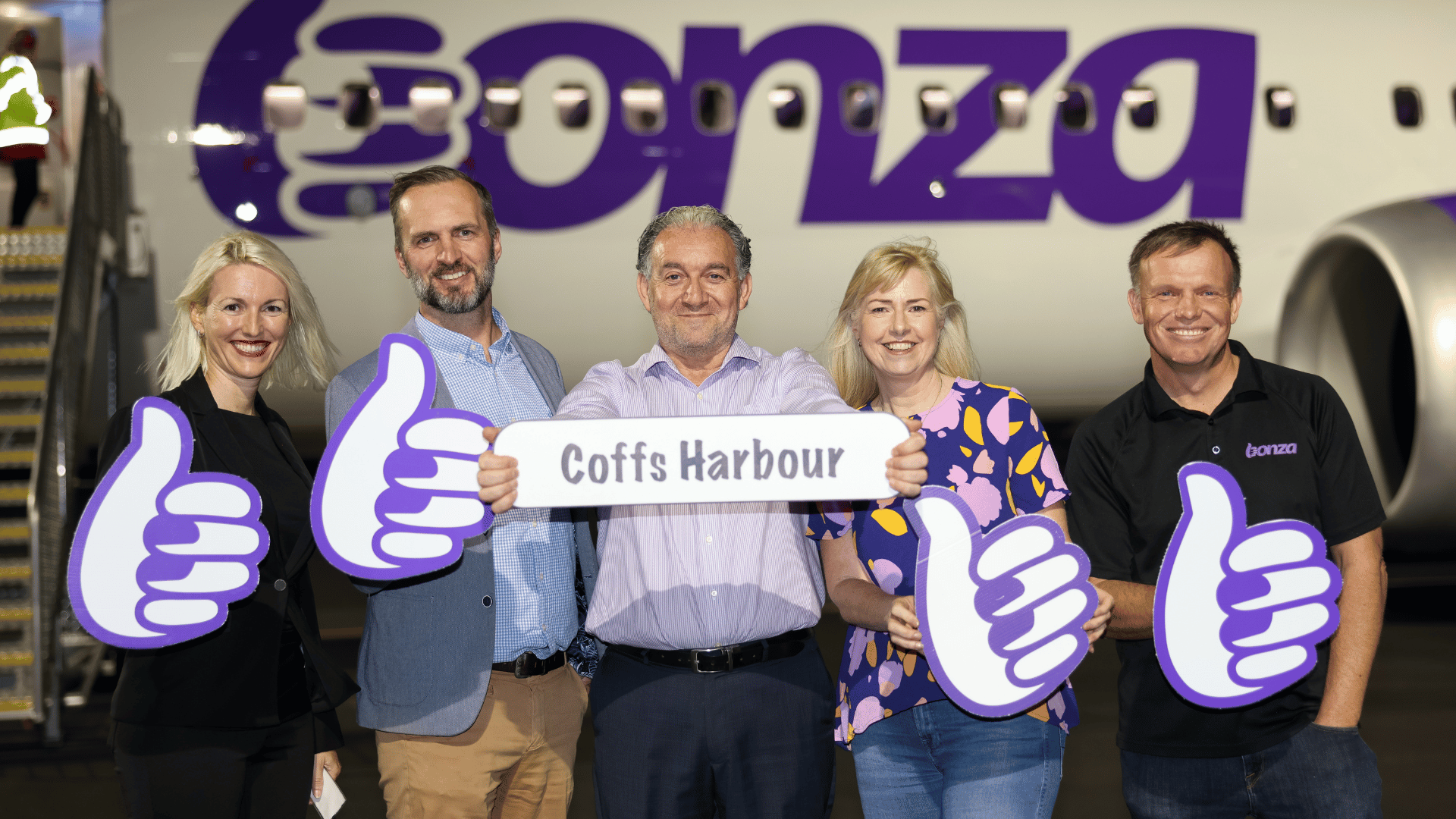 Coffs Harbour Airport GM Frank Mondello, Bonza CEO Tim Jordan, Sunshine Coast Airport GM Infrastructure and Planning Steve Grant, Sunshine Coast Airport GM Corporate Comms Kylie Ezzy and Coffs Coast GM Natalia Cowley holding Bonza thumbs and smiling at camera.